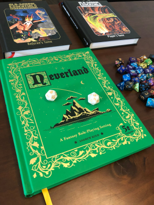 A photo of the Neverland setting book and the OSE Advanced Fantasy tomes on my table, with some dice.